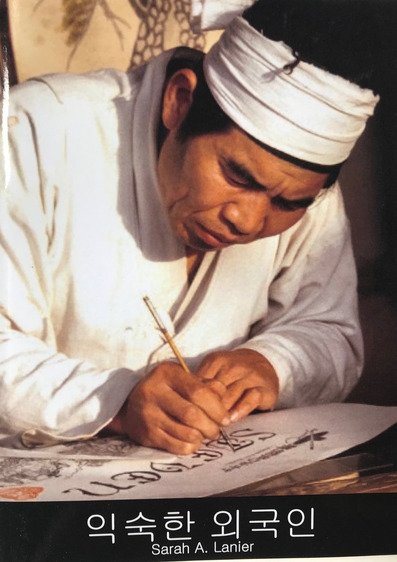 Cover of the Korean edition of the book 'Foreign to Familiar' showing a man in a white robe writing on a scroll with a brush.
